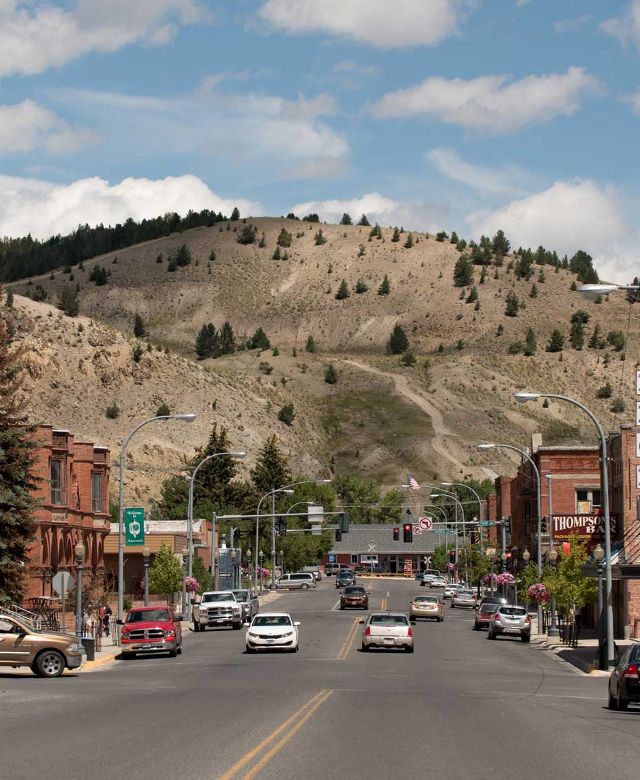 A view down the Main Street of Anaconda towards a large hill.